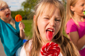 三个女孩在吃棒棒糖，前面的女孩伸着舌头图片素材