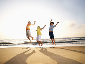 三个孩子在海滩上跳图片素材