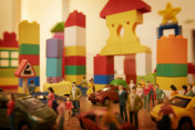玩具汽车和雕像在模拟的塑料街区城镇图片素材