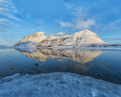 挪威，山倒映在一个冰冻的湖在日落图片素材