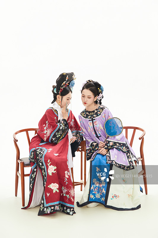 白色背景下穿着中国清朝服饰的两名少女图片素材