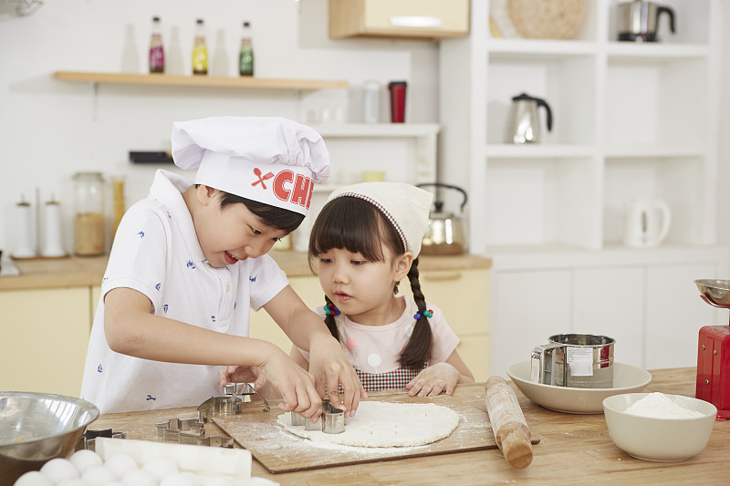 男孩和女孩在家廚房烘焙的照片攝影圖片