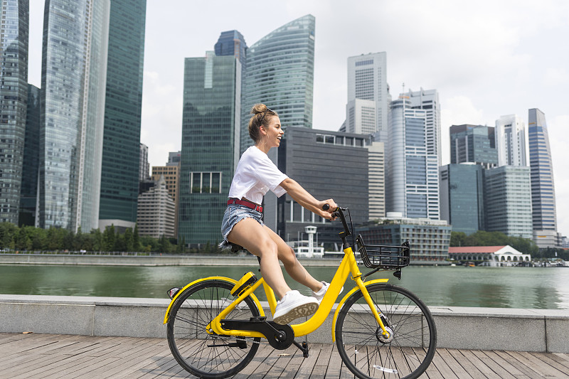 女孩騎著自行車在城市里圖片素材