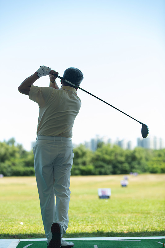 老年人在高爾夫練習場打高爾夫的背影圖片素材