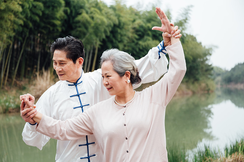 亞洲老年夫婦在湖邊打太極拳圖片素材