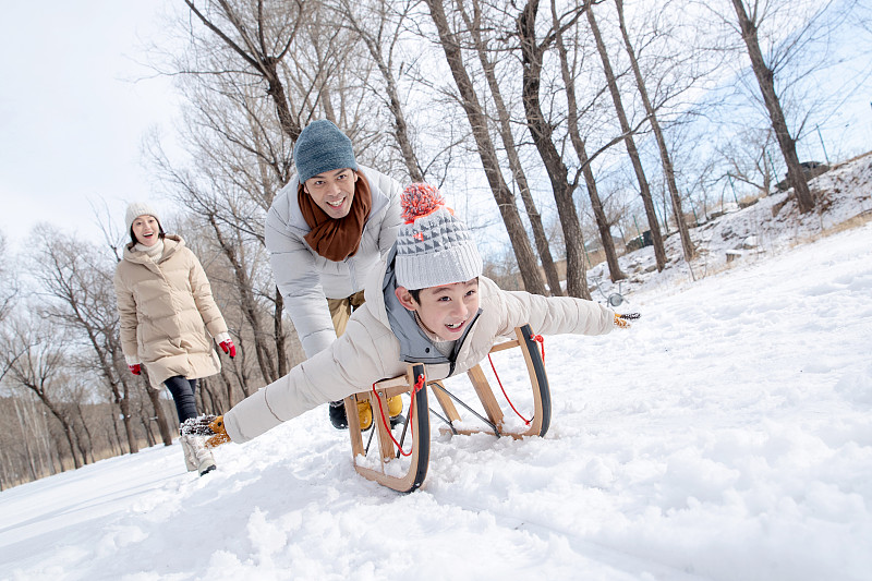 推雪橇玩耍的一家人圖片素材