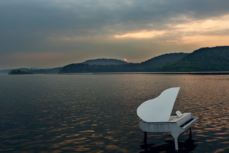 日出中四川綿陽仙海風景區里的白色鋼琴圖片素材