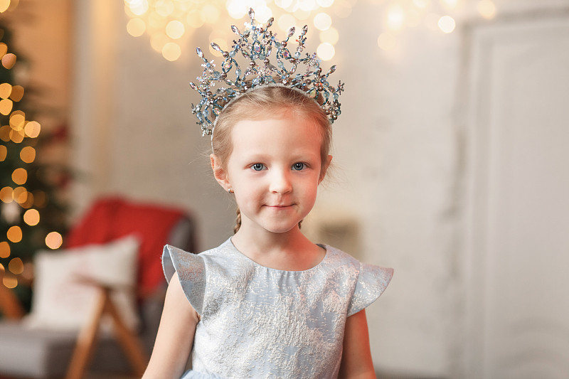 年輕的女孩打扮成公主在圣誕樹旁，俄羅斯圖片素材