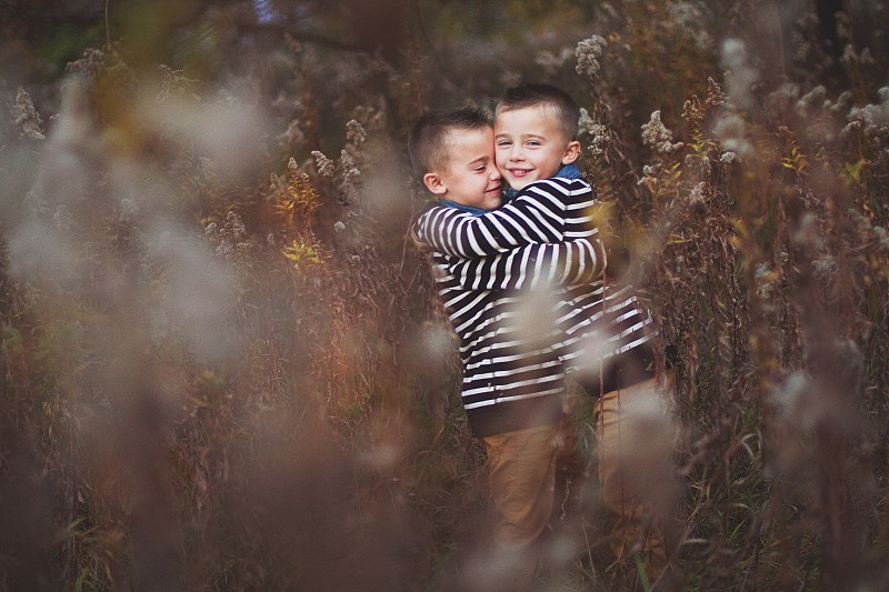 美國伊利諾斯州莉娜市，兩個雙胞胎男孩在秋天的野外擁抱圖片素材