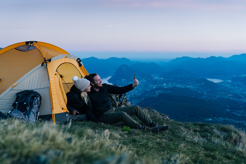 一對情侶在山頂露營時自拍圖片素材