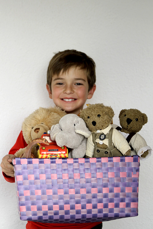 男孩抱著盒子和泰迪熊和玩具圖片素材