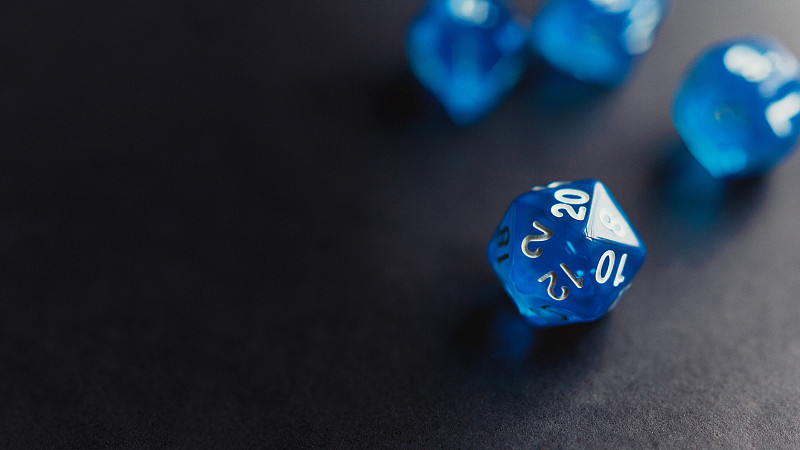 藍色多面體骰子設置在黑暗的背景攝影圖片