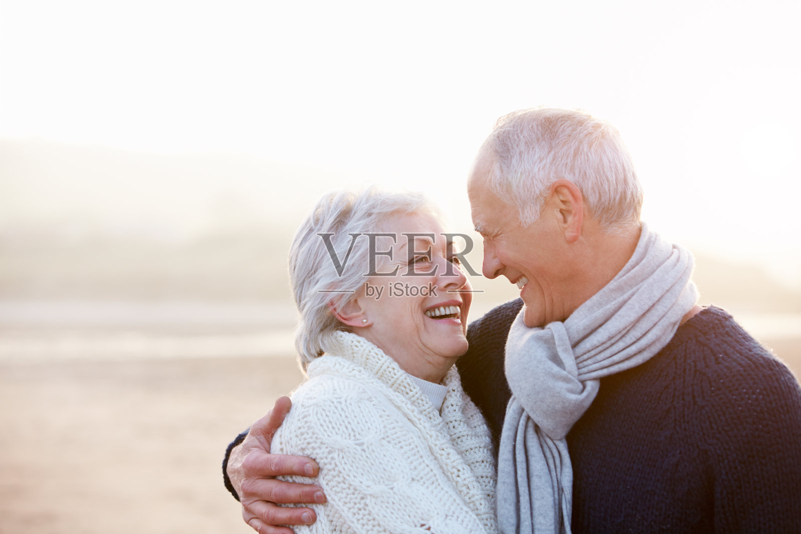 冬季海灘上的浪漫老年夫婦照片攝影圖片