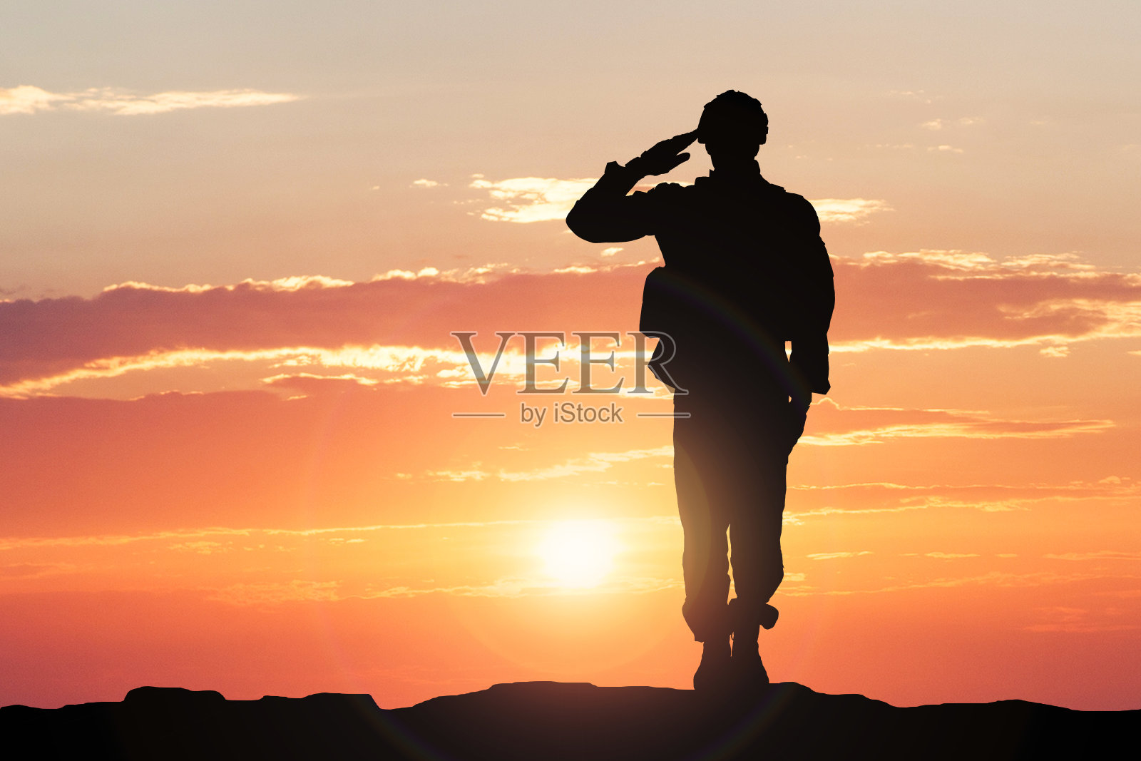 士兵在日落时敬礼照片摄影图片