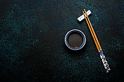 日本寿司筷子和酱油碗在蓝色的黑色石头背景图片素材