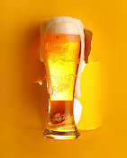 黄色背景下的一杯冰啤酒图片素材