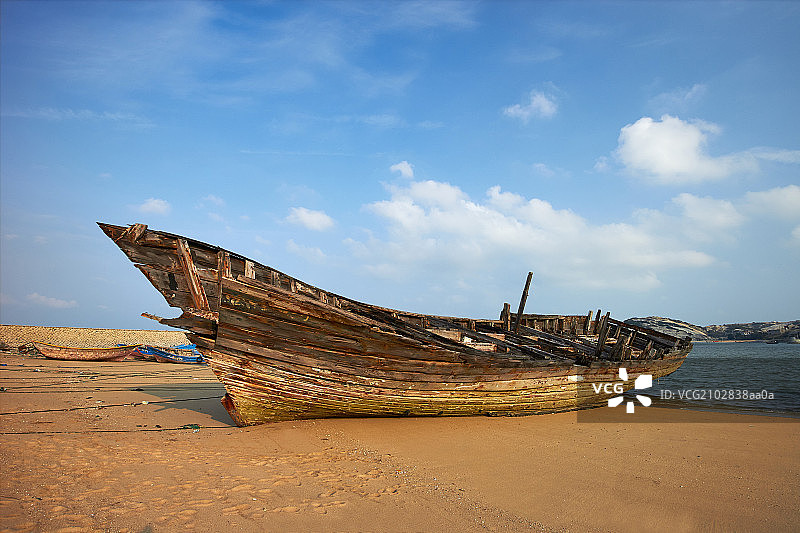 海边沙滩上破旧的渔船图片素材