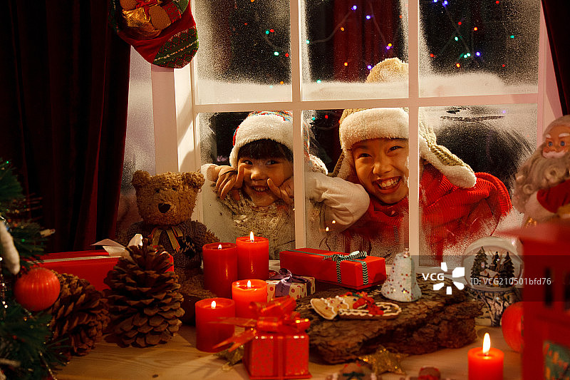 儿童透过窗户看圣诞节礼物图片素材