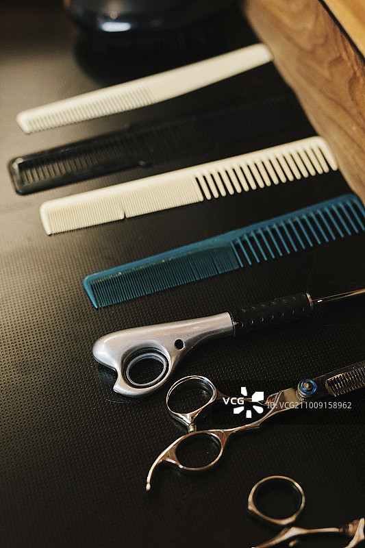 一排梳子和锋利的理发剪刀。图片素材