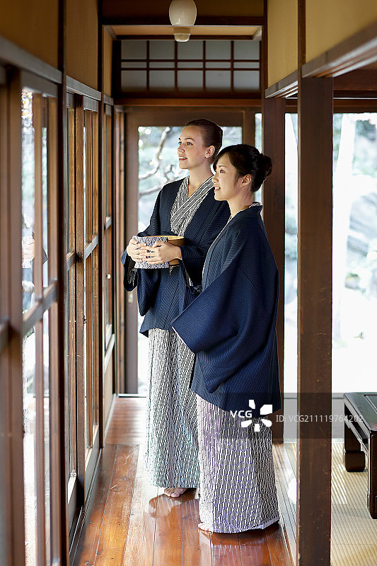 白种女人穿着浴衣与日本朋友在传统的旅馆，东京，日本图片素材