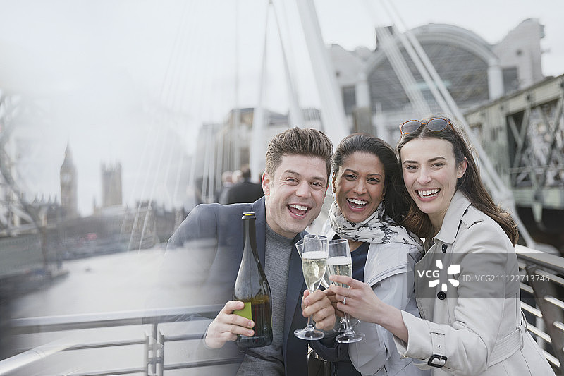 描绘热情的商业人士在城市桥上庆祝，举杯庆祝，英国伦敦图片素材