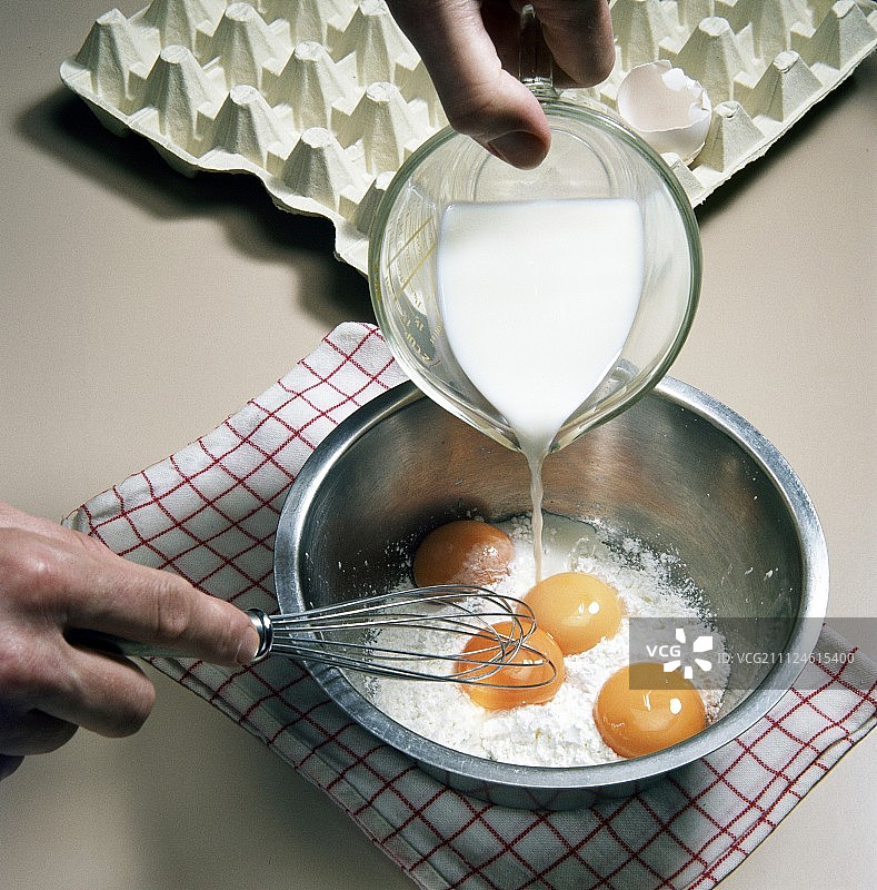 将牛奶倒在面粉和蛋黄上，准备甜点，第一步图片素材