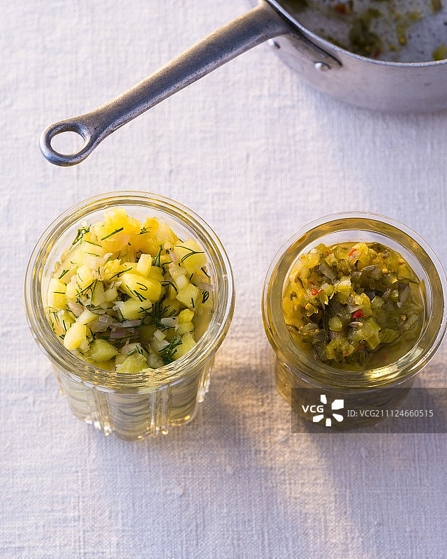 两个玻璃罐黄瓜佐料与姜和黄瓜菠萝沙司图片素材
