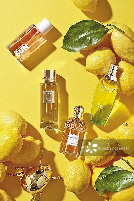 各种各样的香水瓶子在黄色的表面图片素材