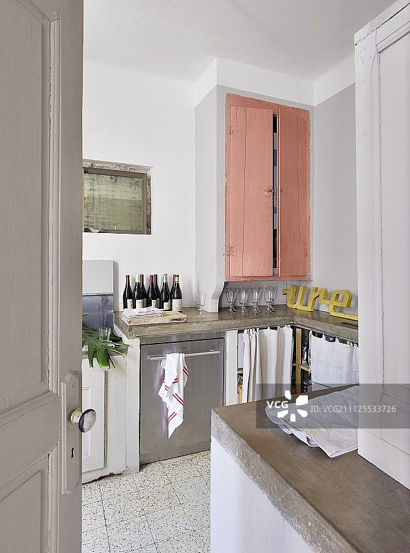在简单的室内设计中，厨房柜台和装有粉色门的橱柜都可以打开图片素材