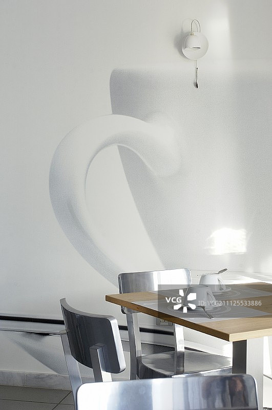 两个地方设置的下午咖啡在设计师桌子前的照片艺术杯图案在白墙上图片素材