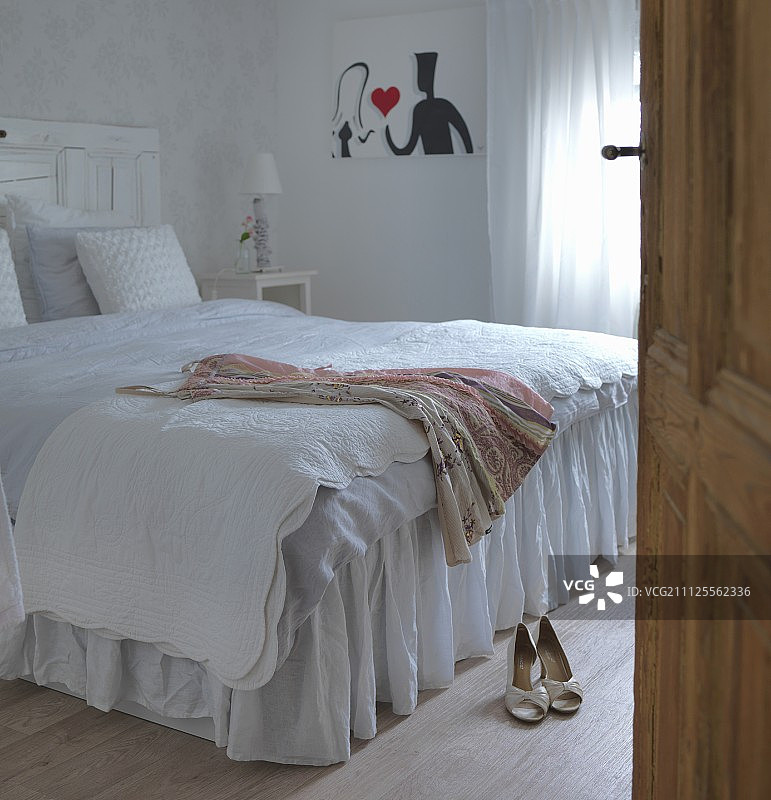 卧室里穿着白色床罩的双人床图片素材