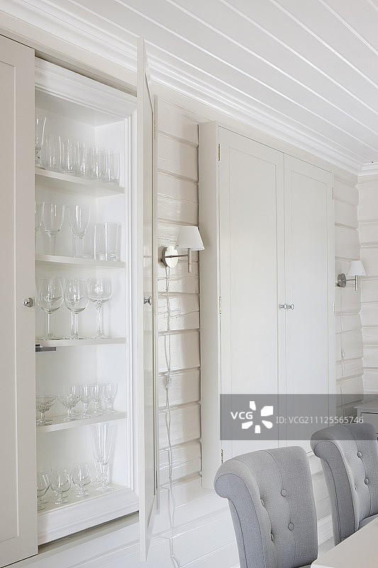 软垫餐椅的靠背和内饰有白色木质墙壁和天花板的展示柜图片素材