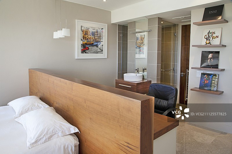 双人床靠半高的隔墙，在浴室前面有桌子图片素材