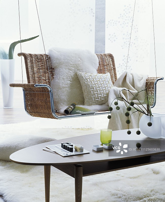 白色羊皮，垫子和毯子舒适，柳条悬挂长椅在复古的内部图片素材