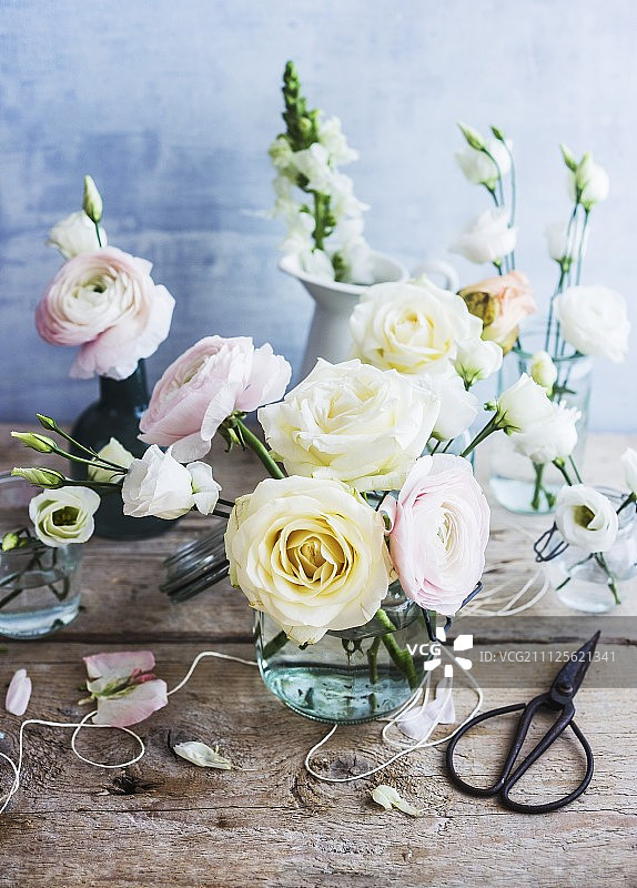 粉彩玫瑰和毛茛的玻璃花瓶图片素材