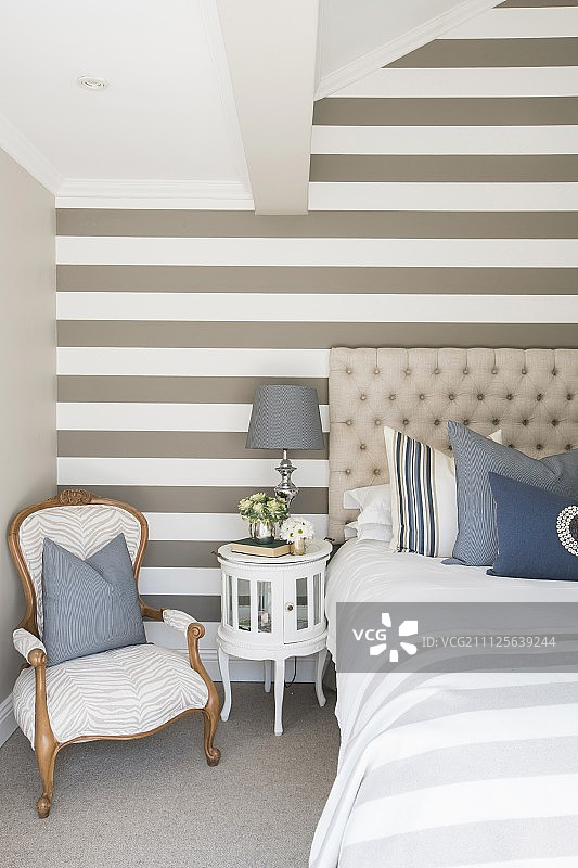 米色，白色和蓝色的条纹强调墙在优雅的卧室图片素材