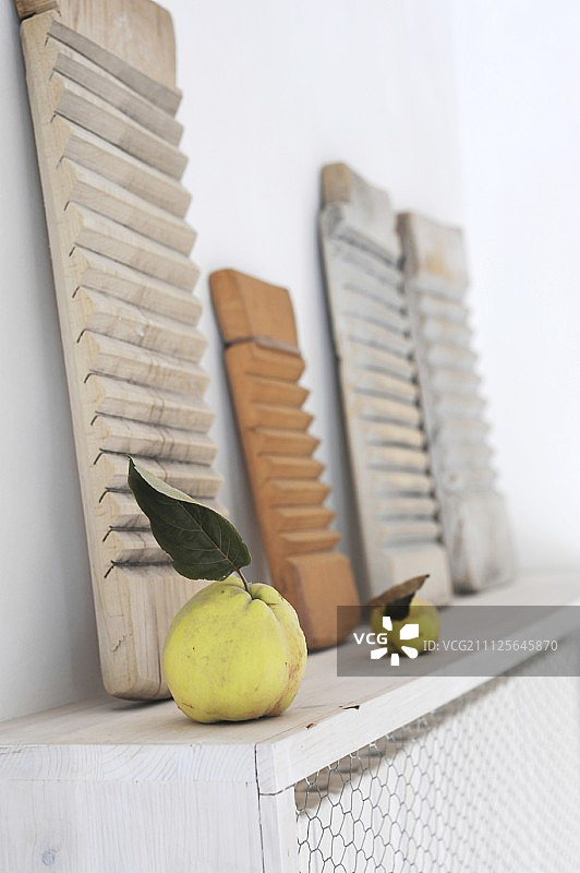 木制的艺术品和水果在木制散热器覆盖与铁丝网前面图片素材