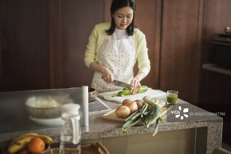 穿着围裙在厨房做饭的女人图片素材