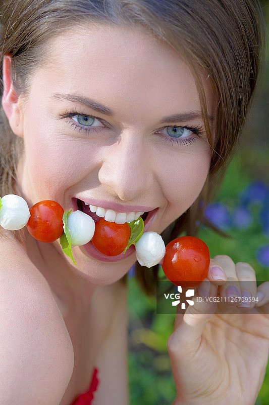 年轻女子配西红柿和马苏里拉芝士串图片素材