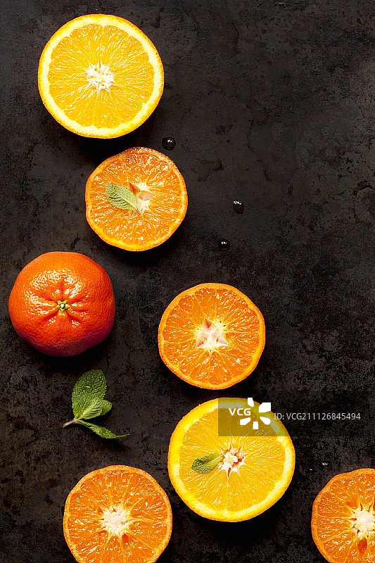 金属托盘上放着对半的橙子和小柑橘图片素材