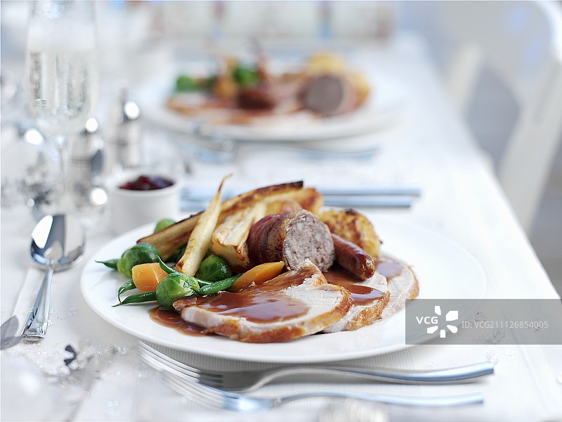 圣诞晚餐，有肉和蔬菜放在节日的桌子上图片素材