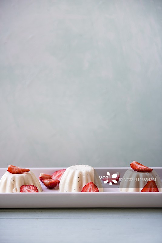 意式奶冻配新鲜草莓放在一个大浅盘上图片素材