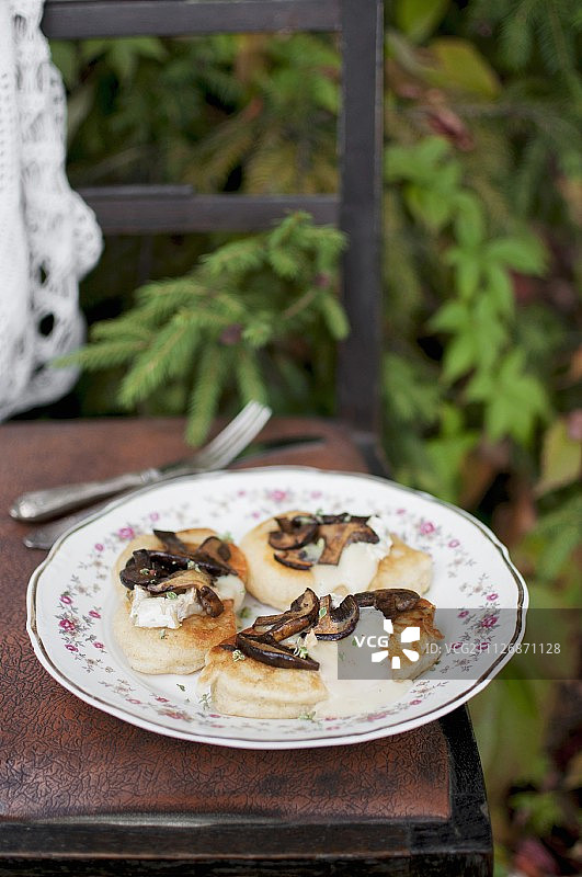 薄饼(由荞麦粉制成的俄罗斯薄饼)配羊乳酪和野生蘑菇图片素材