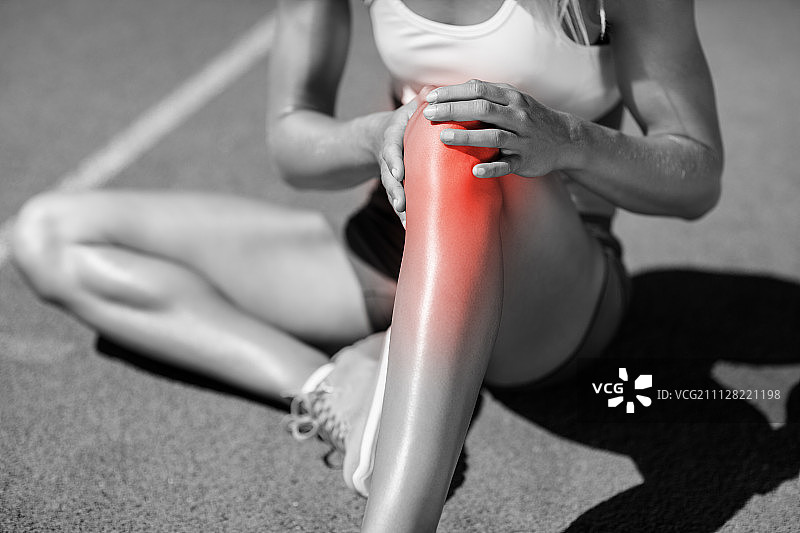 女运动员在阳光明媚的日子里坐在跑道上时关节疼痛图片素材