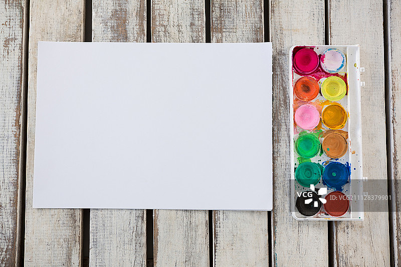 彩色的调色板和白纸排列在木质表面上图片素材