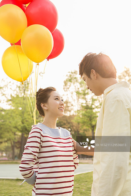 一对夫妇在公园里拿着气球图片素材