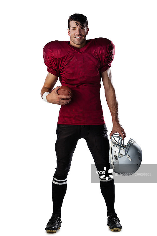肖像微笑的美国足球运动员拿着球和头盔的白色背景图片素材