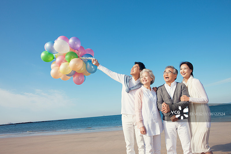 气球和快乐的一家人在海边图片素材