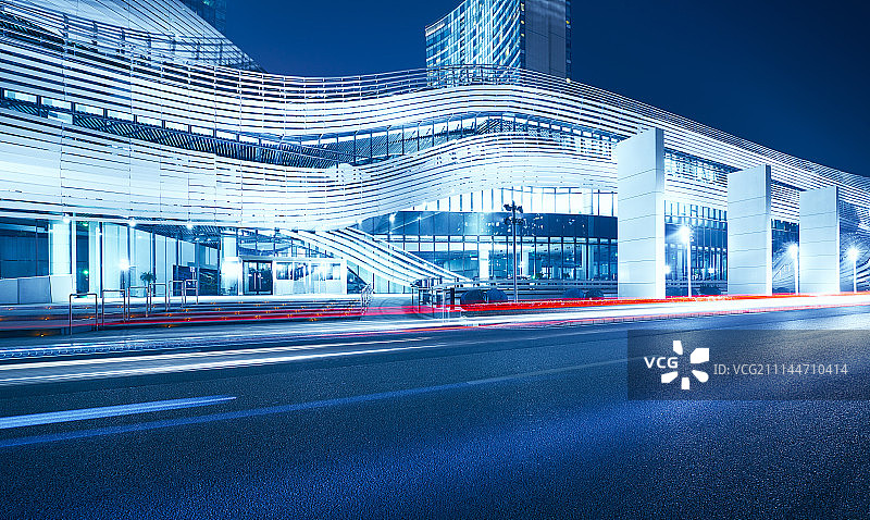 未来感地标建筑繁华夜景和道路光轨效果图片素材
