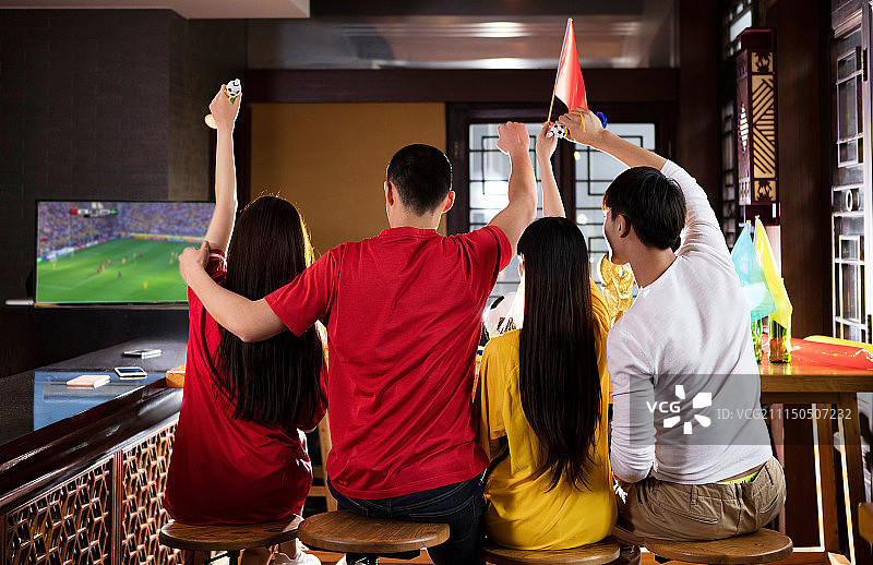 四个球迷在酒吧观看足球比赛喝啤酒图片素材